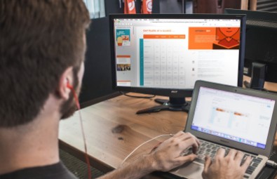 Man typing on a laptop while looking at the monitor
