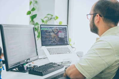 image of man with two laptops